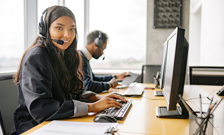 A call center agent working with her headset on inside of the office